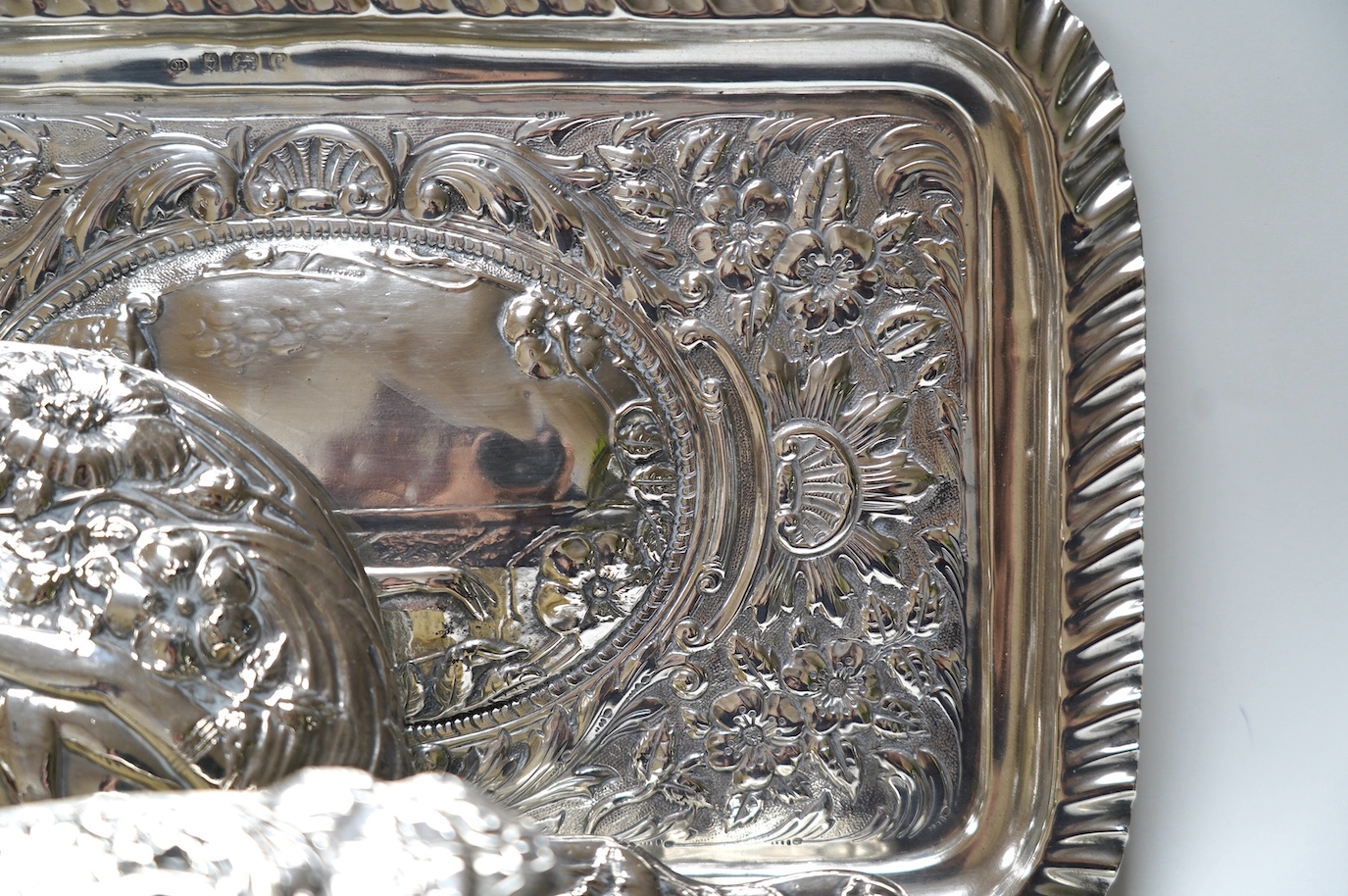 An Edwardian Art Nouveau four piece dressing table set including a tray, Birmingham, 1904, 30.3cm and a similar silver mounted shoe horn. Condition - poor to fair